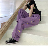 Lila Hose mit weitem Bein und seitlichem Cartoon-Print
